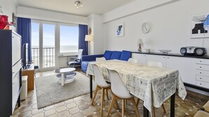 A compact hotel room with a dining area, a kitchenette, and a view of the sea. - Apartment in Blankenberge With Sea Views (Blankenberge)