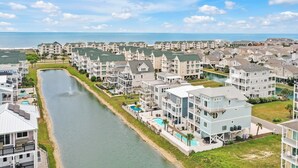 A coastal residential area with multiple-story buildings, a canal, and a beach. - Experience luxury at Salt and Light in Ocean Isle Beach, perfect for 24 guests! (Ocean Isle)