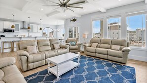 A spacious living room with two beige sofas, a white coffee table, and a blue patterned rug. - Experience luxury at Salt and Light in Ocean Isle Beach, perfect for 24 guests! (Ocean Isle)