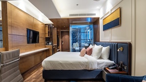 Ein modernes Hotelzimmer mit einem großen Bett, einem Schreibtisch und einer Sitzecke.