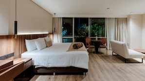A modern hotel room with a large bed, a desk, a chair, and a view of the city at night. - w Lotf Mountain View Low Floor (Medellín)