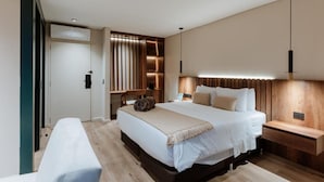 A modern bedroom with a large bed, bedside tables, a bench, and a built-in wardrobe. - w Lotf Mountain View Low Floor (Medellín)