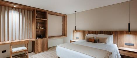 Une chambre moderne avec un grand lit, une tête de lit en bois, des tables de chevet, un bureau et une bibliothèque intégrée.