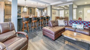 A spacious living area with a leather sofa, a coffee table, and a dining area with bar stools. - Mountain Views & Brook Access: Home in Arkville! (Arkville)