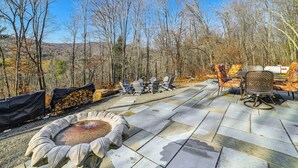 An outdoor patio with stone flooring, Adirondack chairs, and a fire pit. - Mountain Views & Brook Access: Home in Arkville! (Arkville)