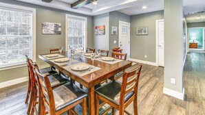 A dining room with a large wooden table set for six, surrounded by wooden chairs with cushioned seats. - Mountain Views & Brook Access: Home in Arkville! (Arkville)