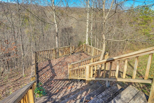 A wooden staircase leading up a hill in a forested area.