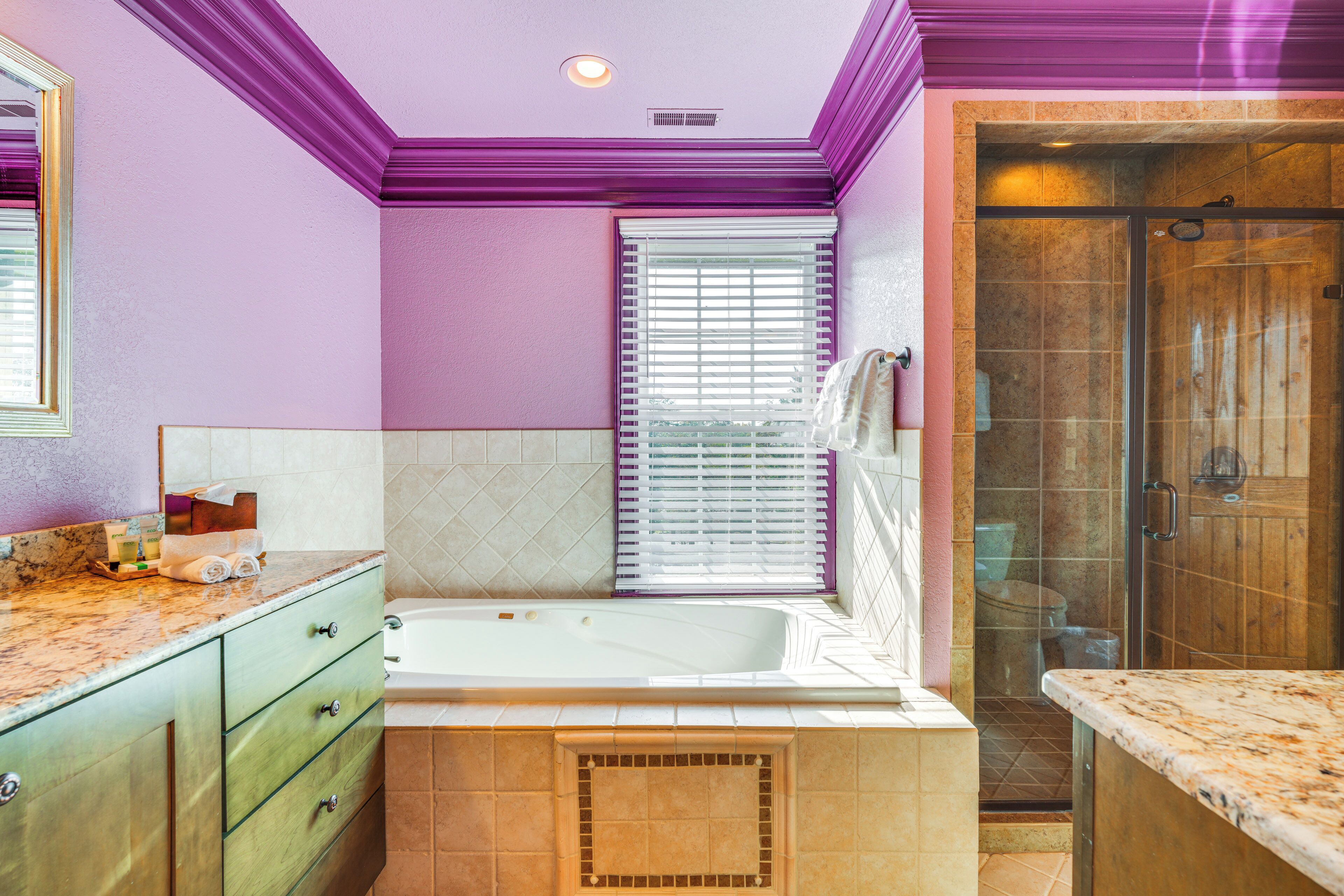 A bathroom with a bathtub, a shower, and a vanity with drawers.