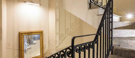 A spiral staircase with ornate black railings and a marble finish.