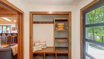 A wooden interior with a bench, a basket, and a pillow with text.