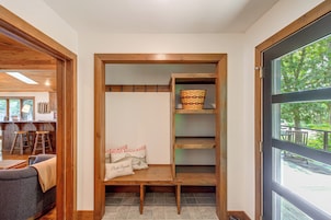 Interior de madera con un banco, una cesta y un cojín con texto.