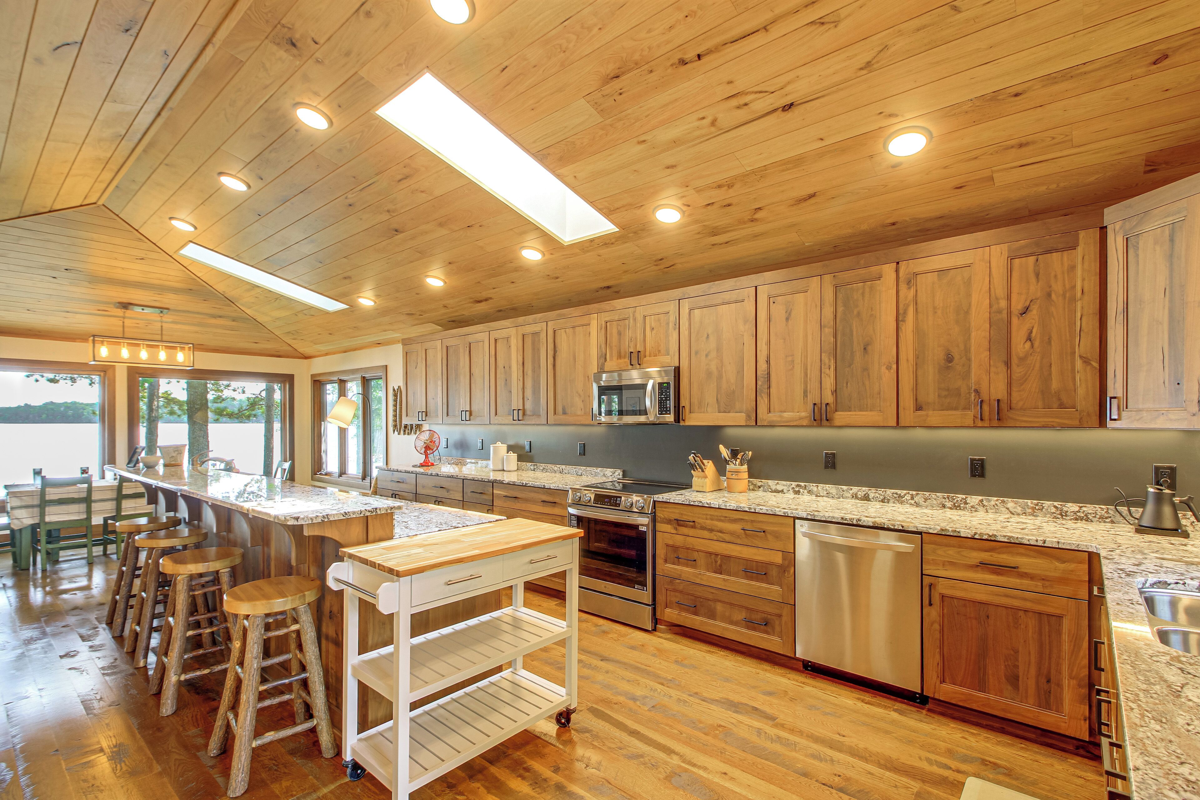 A spacious kitchen with wooden cabinets, a central island, and modern appliances.