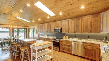 A spacious kitchen with wooden cabinets, a central island, and modern appliances.
