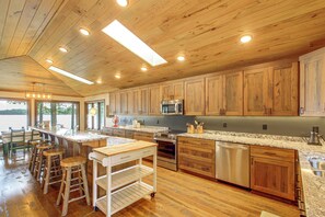 A spacious kitchen with wooden cabinets, a central island, and modern appliances. - Short Drive to Itasca State Park - Waterfront Home (Park Rapids)