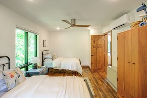 A bedroom with two beds, a ceiling fan, a window with curtains, a bedside table with a lamp, and a wardrobe. - Short Drive to Itasca State Park - Waterfront Home (Park Rapids)