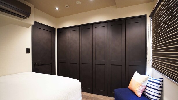 A bedroom with a bed, a sofa, and a wardrobe. - Real Life Iidabashi Stylish 1-bedroom 3 Mins Subway (Tokyo)