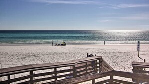 A beach with a wooden boardwalk leading to the water. - Walk to White-sand Beach: Resort Condo in Destin! (Destin)