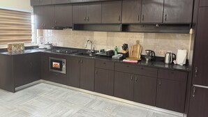 Una cucina moderna con mobili scuri, un fornello a gas, un forno a microonde e un lavello.