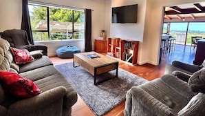 Ein modernes Wohnzimmer mit Sofa, Couchtisch und einem an der Wand montierten Flachbildfernseher.