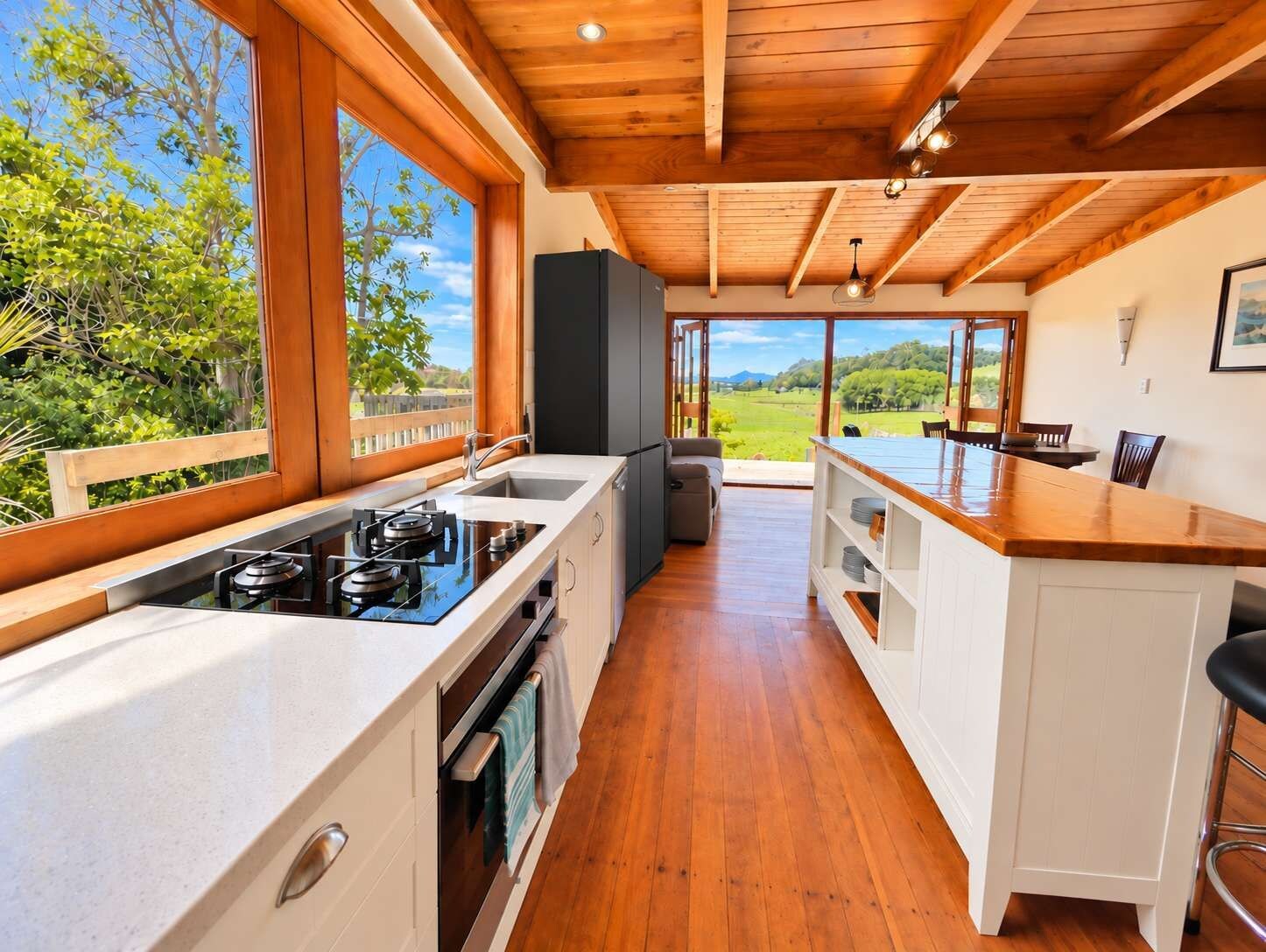 Una cocina moderna con un ventanal grande, techo de madera y vistas al exterior.