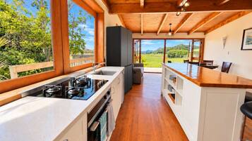 Una cocina moderna con un ventanal grande, techo de madera y vistas al exterior.