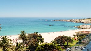 A beach with clear turquoise water, a sandy shore, and palm trees. - Apartment w Sea Views by Camps Bay Beach Kyanos (Cape Town)