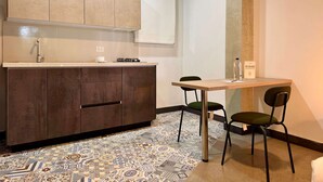 Een moderne keuken met een inbouw kookeiland, een eethoek met twee stoelen en een vloer met een patroon.