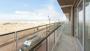 A balcony with a view of the beach and a train track. - Flat in Blankenberge With Ocean Views (Blankenberge)