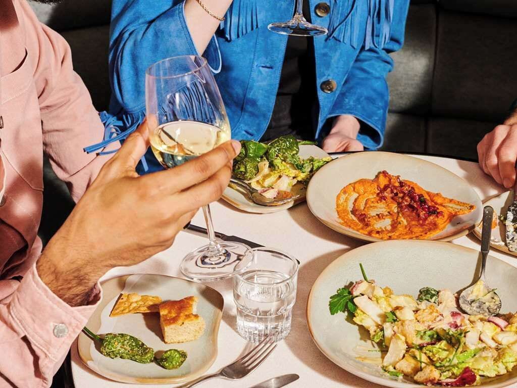 A dining table with various dishes, glasses, and cutlery.