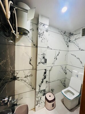 Family Room | Bathroom | Shower, towels, soap, toilet paper - Hotel Yashoda (Ujjain)
