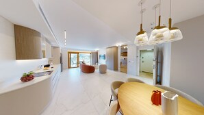 A modern kitchen with a marble countertop, a dining area with a wooden table and chairs, and a living space with a sofa and a TV. - ★Prestigious King David 3BR/3BA  - View! Pool & Gym★ (Jerusalem)