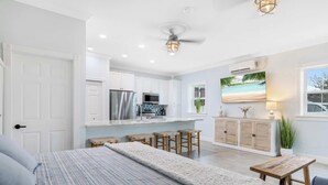 A modern bedroom with a large bed, a wooden bench, and a small table. - Cozy Studio Condo in Sebastian! (Sebastian)
