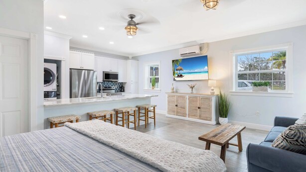 A modern kitchen with a built-in oven, refrigerator, and microwave. There is a dining area with a wooden table and chairs. - Cozy Studio Condo in Sebastian! (Sebastian)