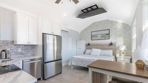 Una cocina moderna con electrodomésticos de acero inoxidable, encimera de mármol y zona de comedor con mesa y banco de madera.