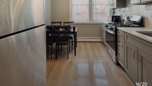 A compact kitchen with a refrigerator, stove, and dining table.