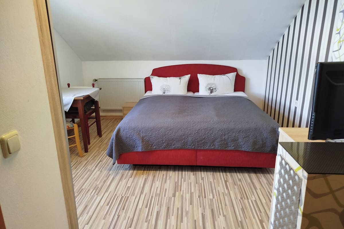 Ein Schlafzimmer mit Bett, Schreibtisch und Stuhl.