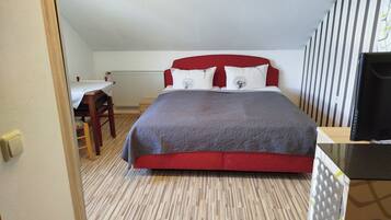 Un dormitorio con una cama, un escritorio y una silla.