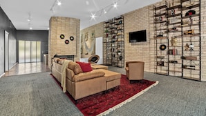 Een moderne woonkamer met een bakstenen muur, een bank, een fauteuil en een boekenplank.