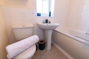 A bathroom with a toilet, sink, and bathtub. - Mandarin Styles 3 Bedroom W/garden in Derby (Derby)