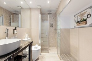 Een moderne badkamer met een groot wastafel, toilet en douchehoek.