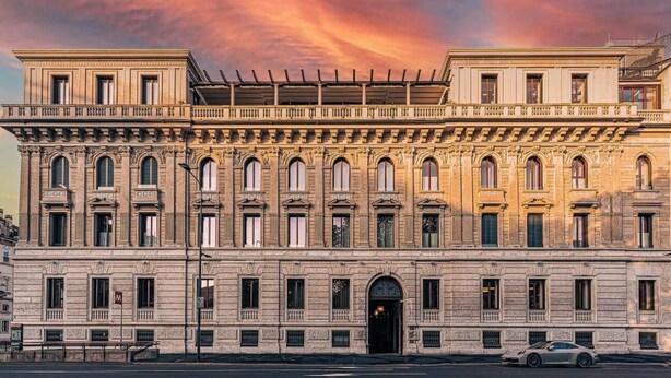 Un edificio histórico con fachada simétrica, ventanas amplias y una entrada central.