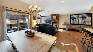 Amplia sala de estar con una mesa de comedor de madera, un sofá grande y una chimenea.