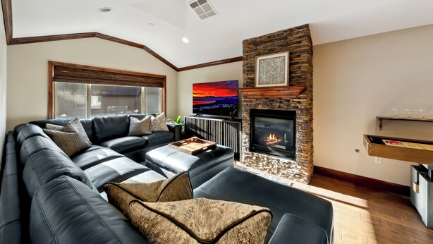Una sala moderna con un sofá modular, una chimenea y vistas a la ciudad.