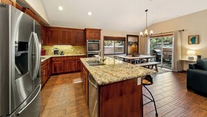 Una cocina moderna con armarios de madera, electrodomésticos de acero inoxidable y encimera de granito.