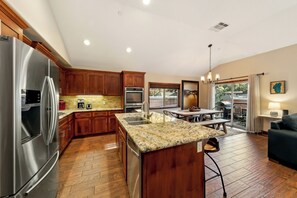 Eine moderne Küche mit Holzausstattung, Edelstahlgeräten und einer Arbeitsplatte aus Granit.