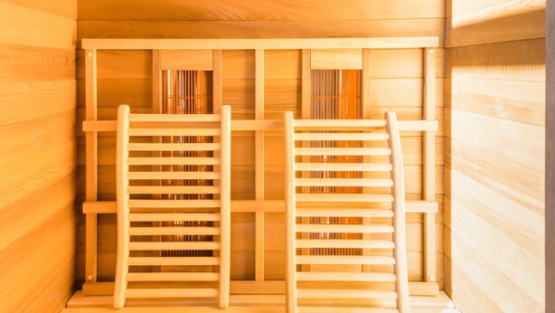 Un sauna avec deux bancs en bois et un plafond en bois.