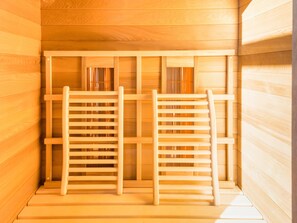 A sauna with two wooden benches and a wooden ceiling. - Stylish Retreat With Sauna (Saint-Hubert)