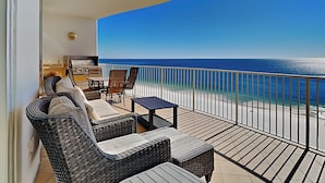 A balcony with wicker furniture, a small table, and a view of the ocean. - Turquoise Place #1107C | Gulf Front, Private Hot Tub + Resort Amenities (Orange Beach)