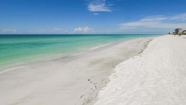 A beach with clear turquoise water and white sand. - 4-bedroom house on Longboat Key with private beach access only 150 yards away. (Longboat Key)