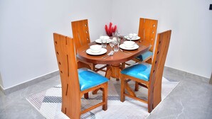 A dining table set with plates, glasses, and cutlery. - Sky park view apartment (Syokimau)